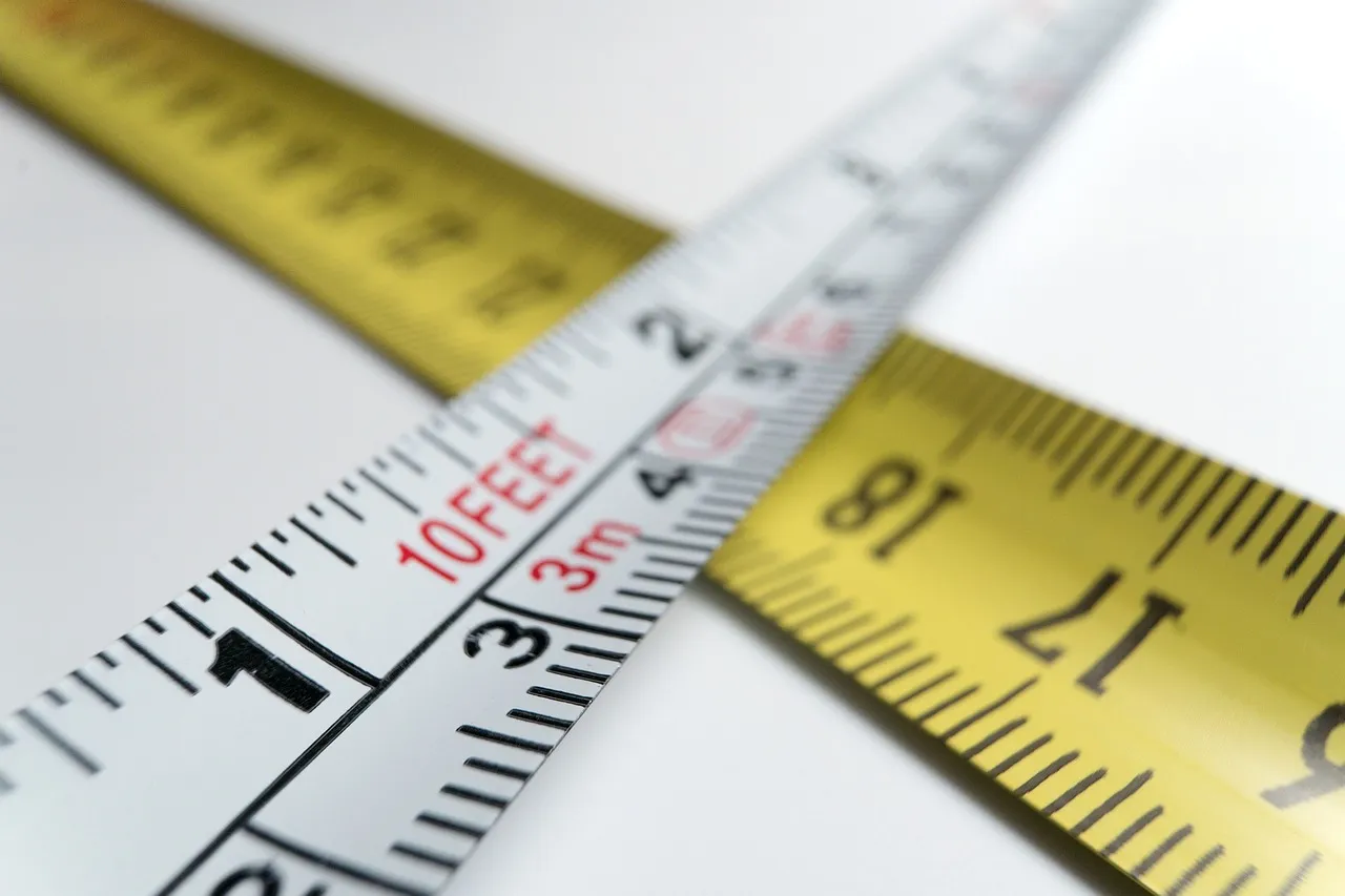 A metric tape and an imperial tape crossing each other, their scales marked in different units
