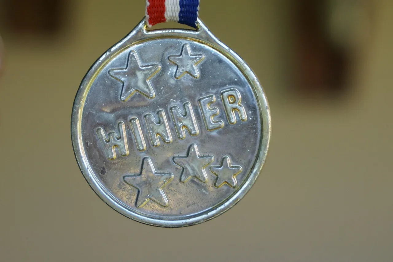 A silver medal engraved with the word winner
