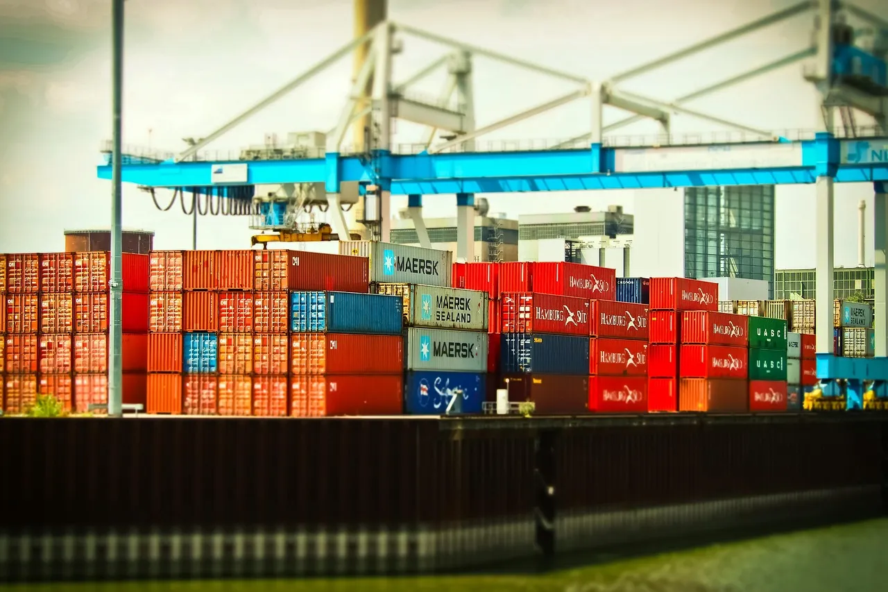 Stacked shipping containers and gantry cranes at a container port