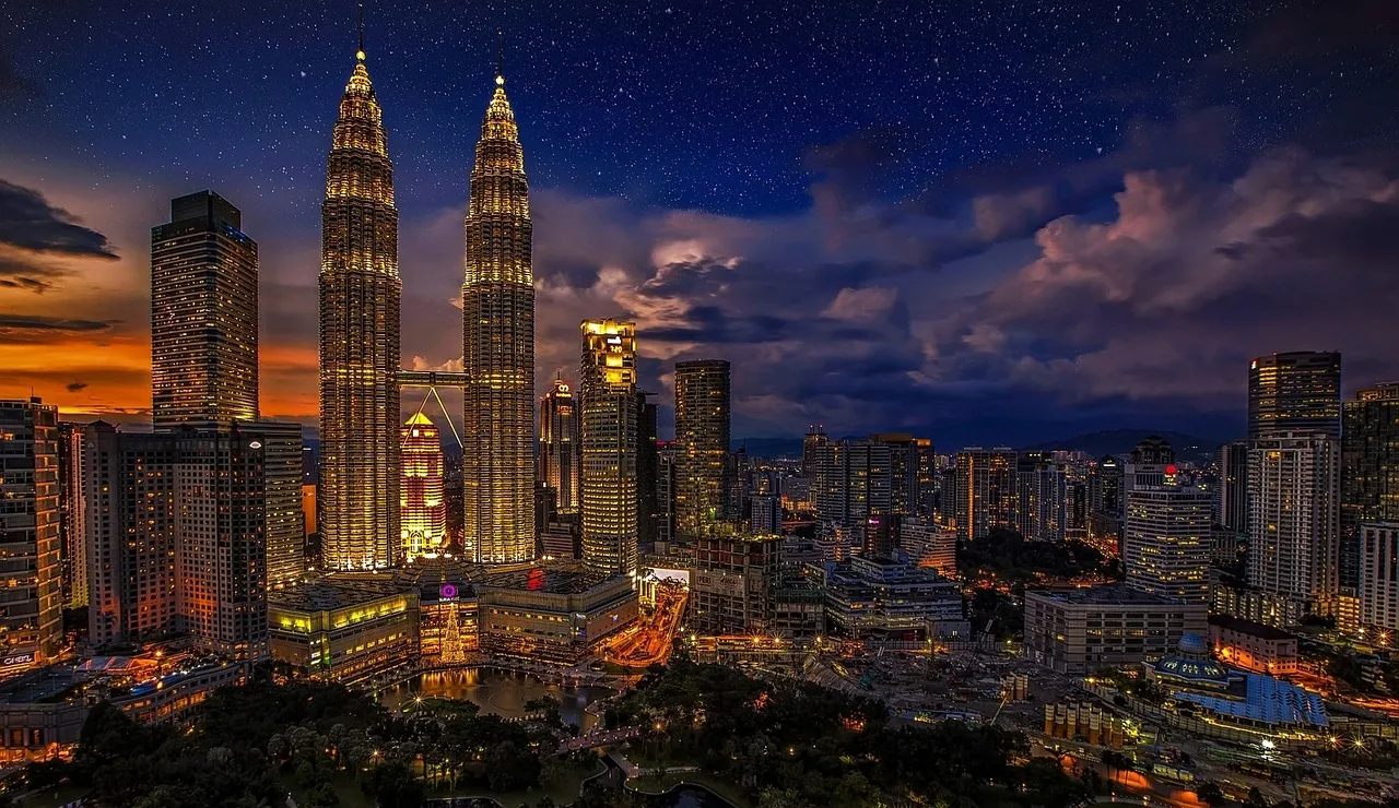 The Kuala Lumpur skyline at dusk, the Petronas Towers lit above the city