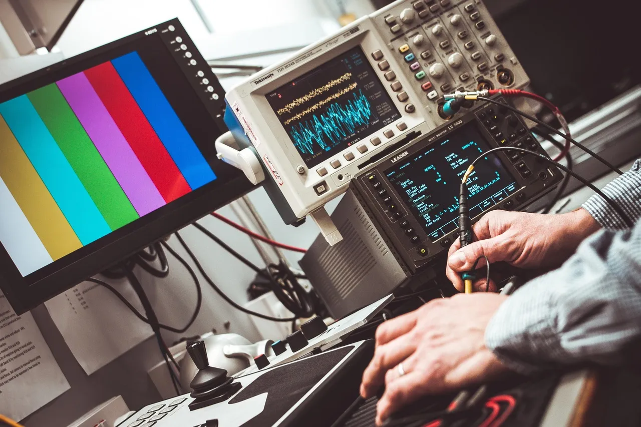 An engineer probing a circuit at a lab bench, an oscilloscope behind showing a distorted waveform