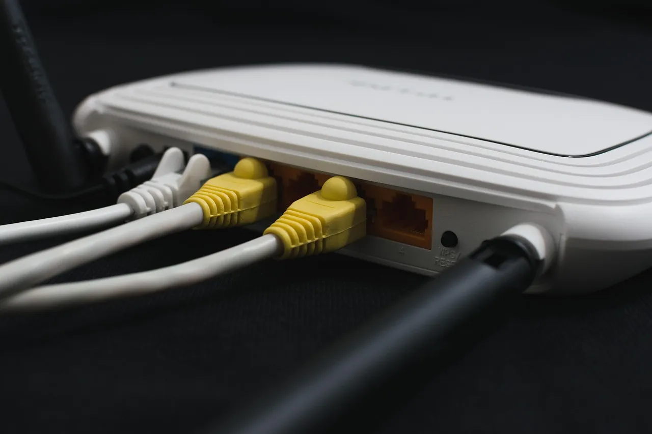 Ethernet cables plugged into the back of a white home broadband router