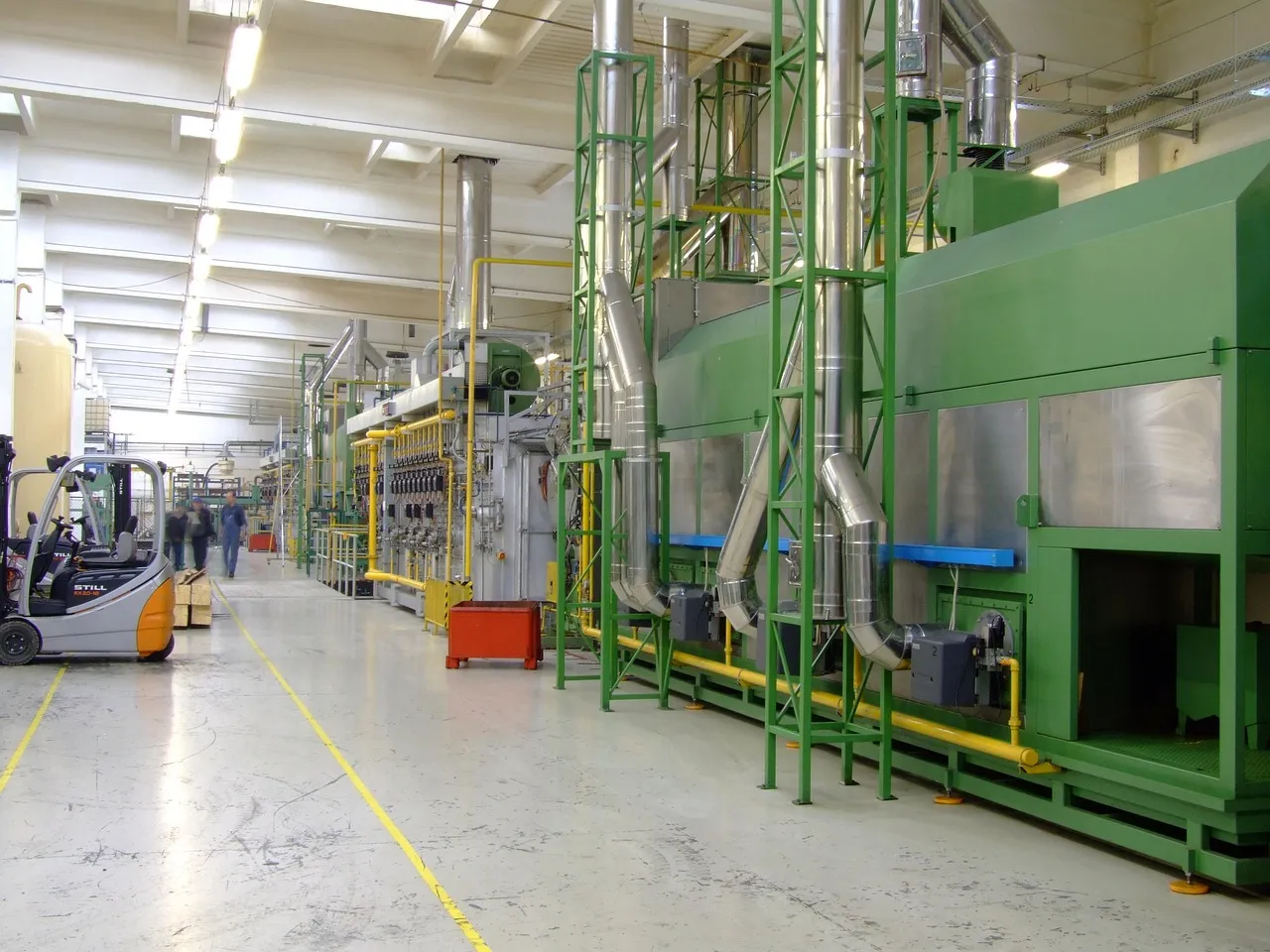 An industrial production line running the length of a factory hall — illustrating the anode manufacturing capacity this commitment is meant to expand.