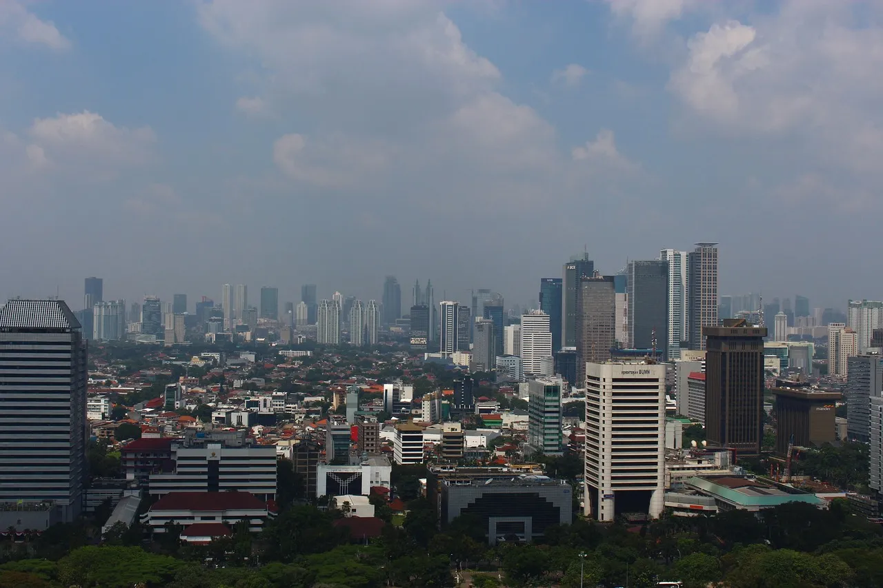 A dense city skyline seen through visible haze, with tower blocks fading into grey air toward the horizon