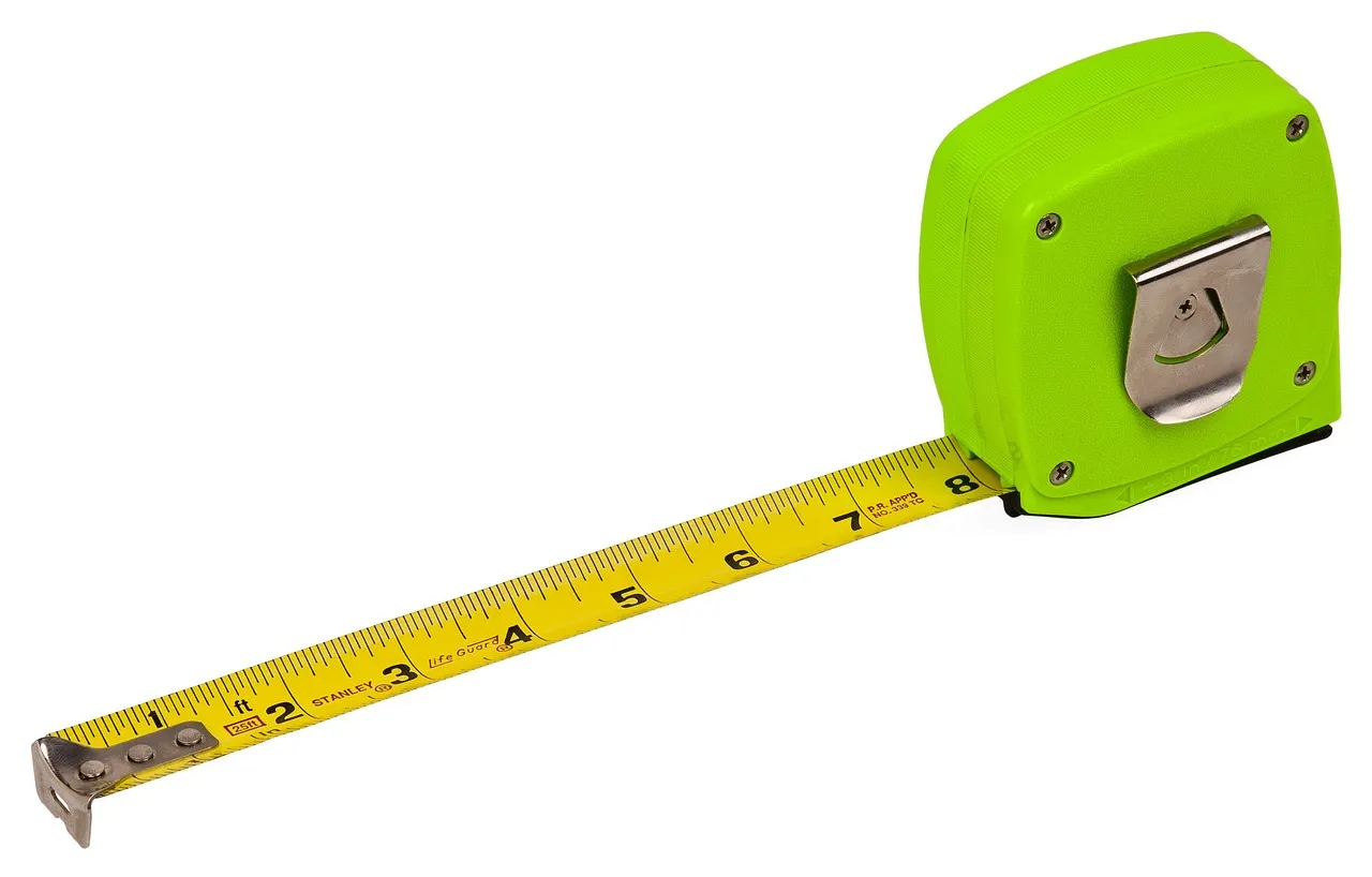 A green tape measure with its yellow blade pulled out, on a white background