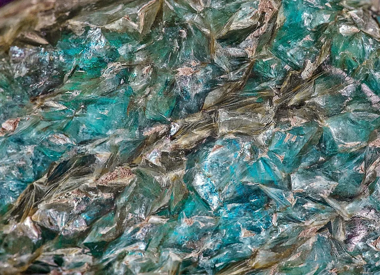 Close-up of a blue-green crystalline mineral with a glassy, layered surface.
