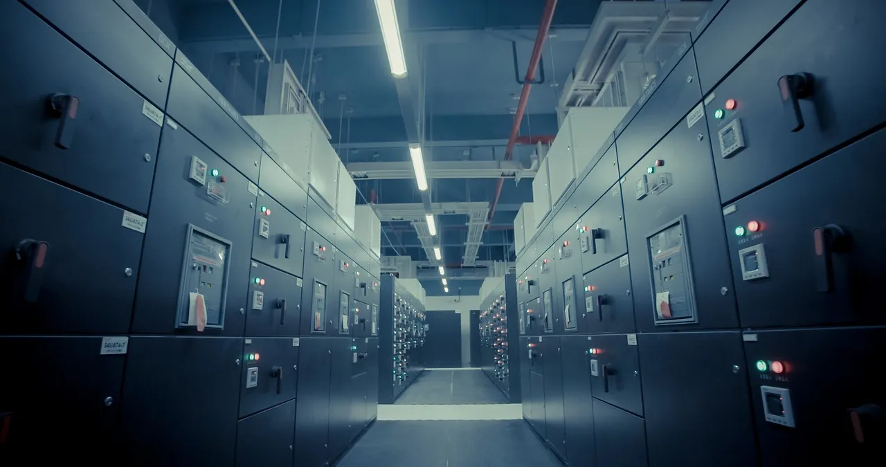 A row of electrical switchgear cabinets, the kind of infrastructure that is financed with debt rather than venture equity