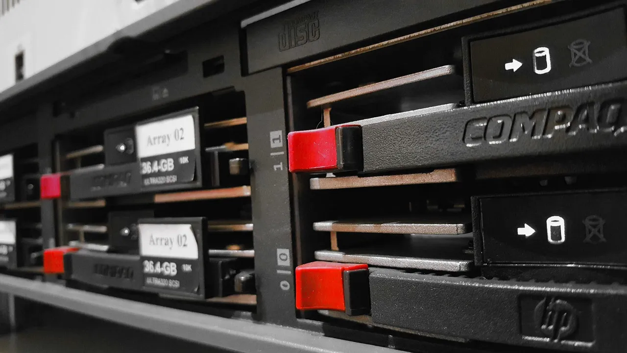 A close-up of rack-mounted server hardware, with drive bays and status markings in shadow.