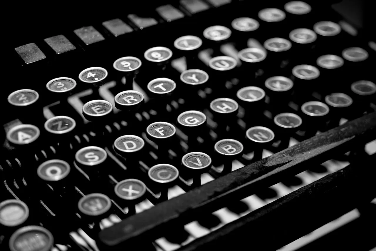A close view of typewriter keys in monochrome