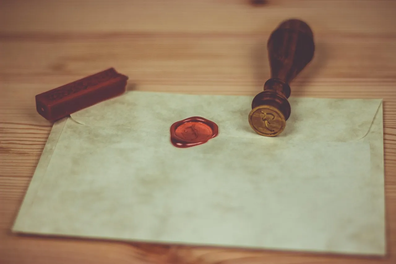A red wax seal pressed into an envelope, with the brass matrix that made it lying alongside — illustrative of a signing key, whose value rests entirely on only one party holding the stamp.