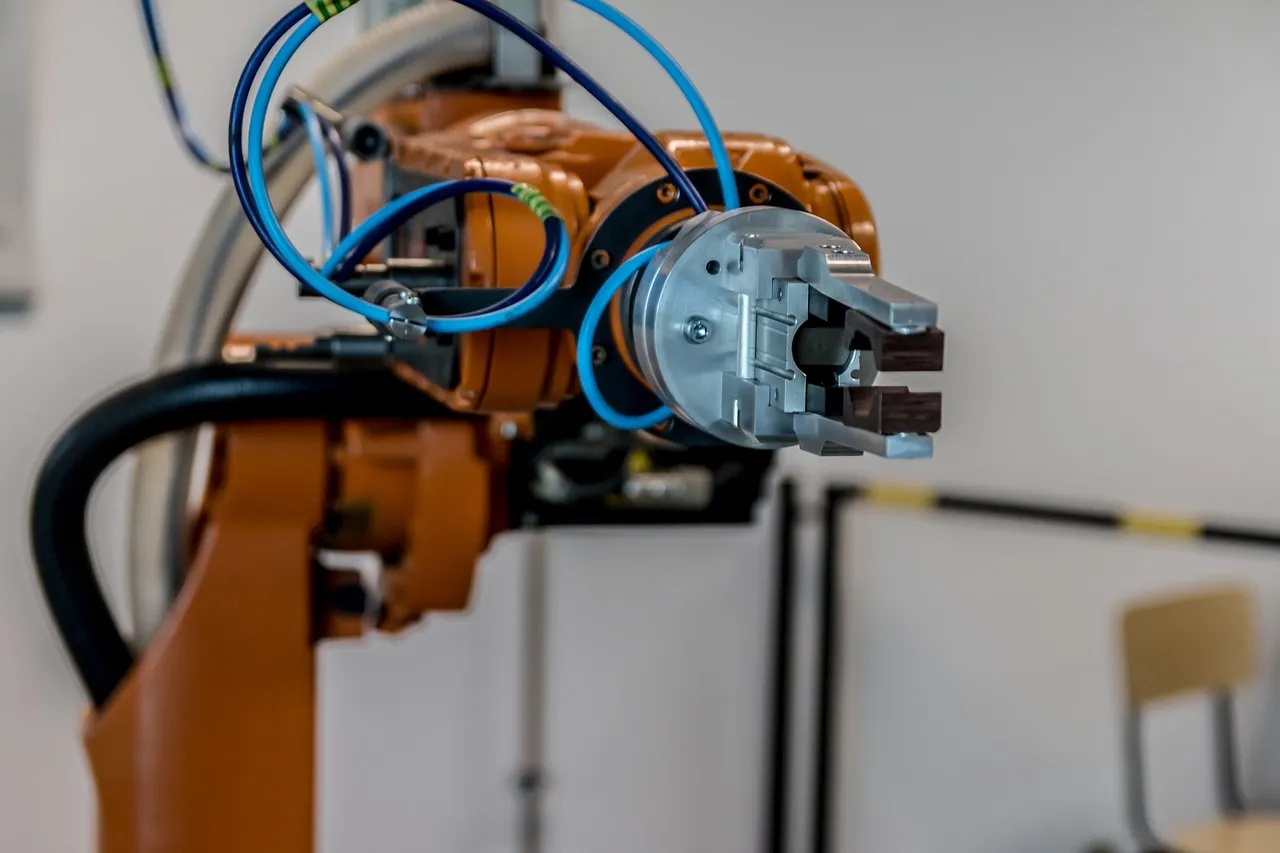 An industrial robot arm on a factory line — illustrating the physical-AI market these image sensors are being built for.