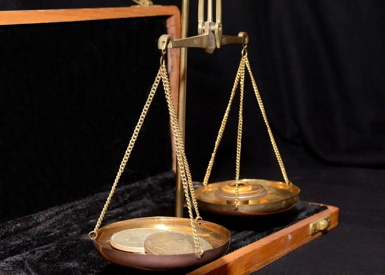 An antique brass balance scale with two hanging pans