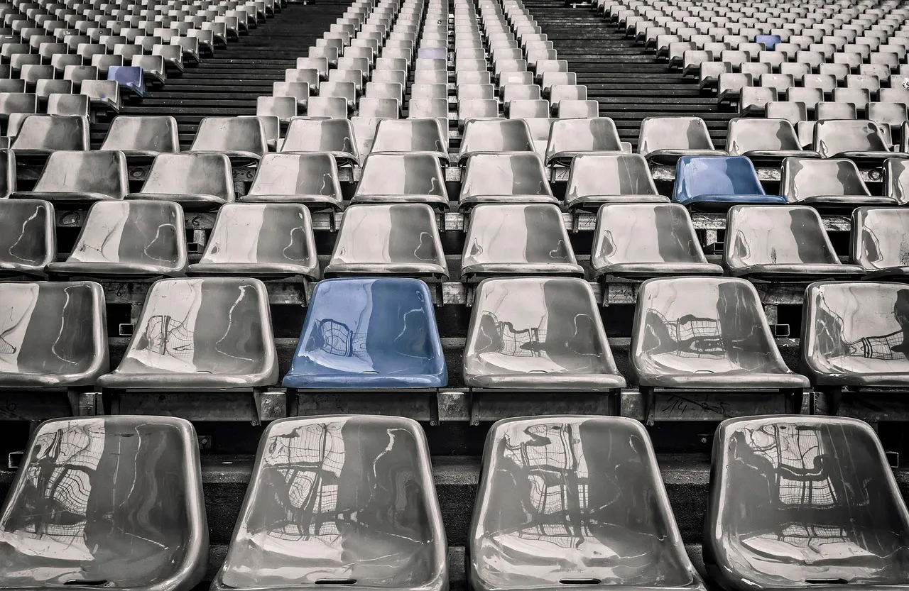 Rows of empty stadium seats, illustrating an audience figure that may not be counting people.