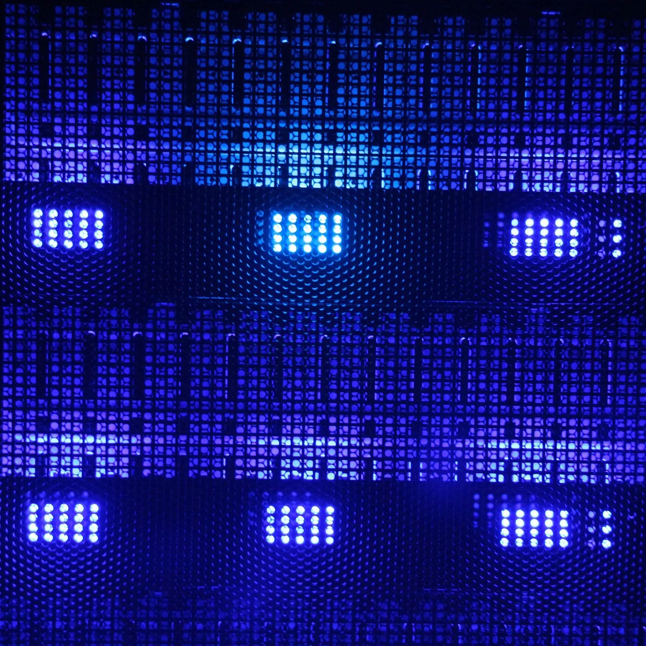 Server front panels lit by blue indicator LEDs behind a mesh door, illustrating a report on attackers exploiting MLflow to steal cloud credentials.