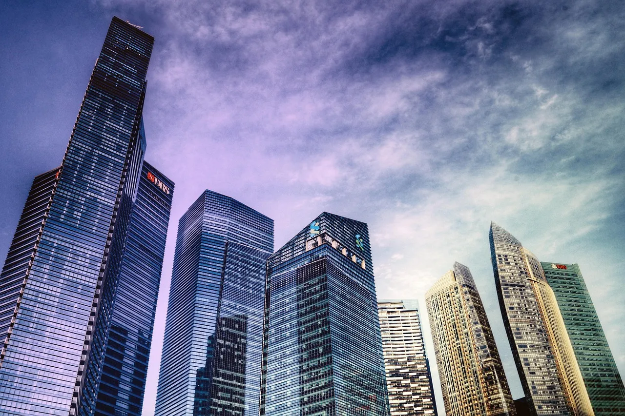 Office towers in Singapore's central business district photographed from street level at dusk