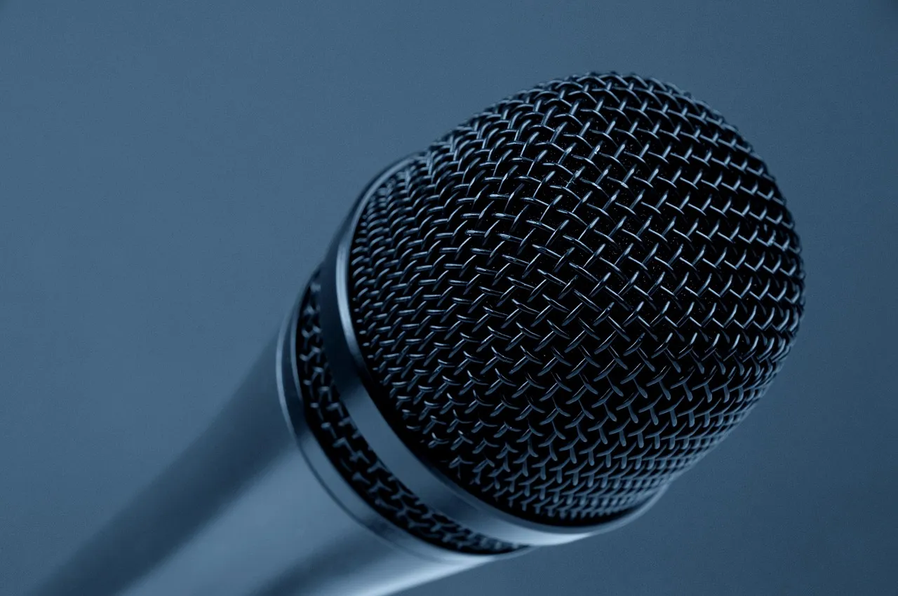 Close-up of a microphone grille against a blue background