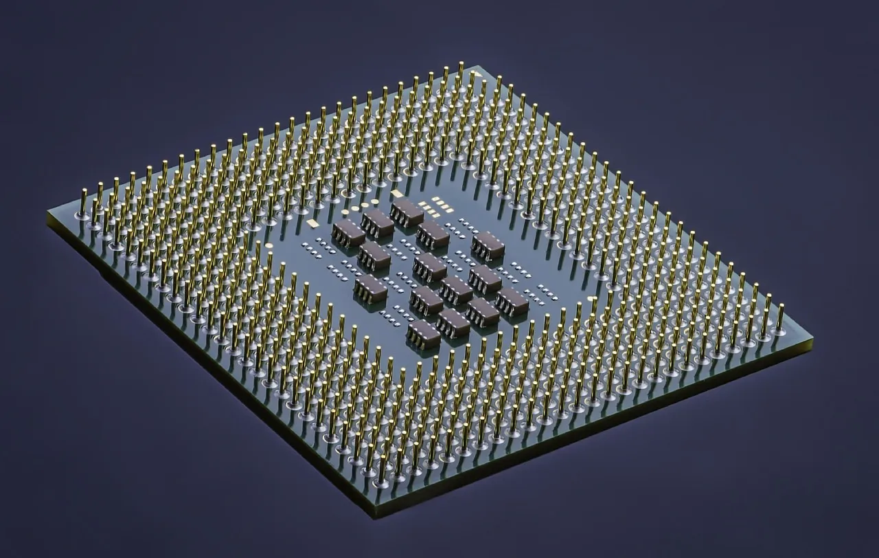 The underside of a processor package, showing its grid of gold contacts surrounding an exposed die.