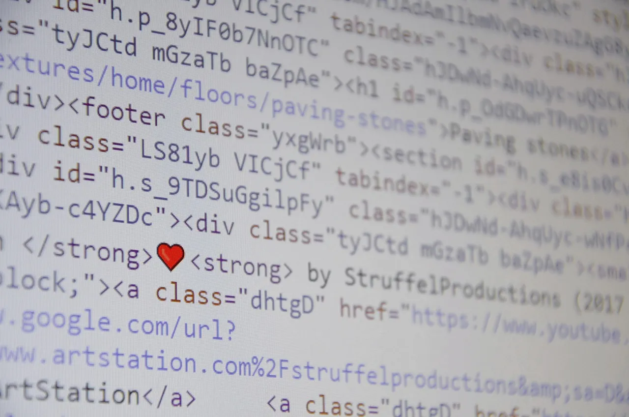 A close-up of HTML source code displayed on a bright computer screen, the text running off both edges of the frame
