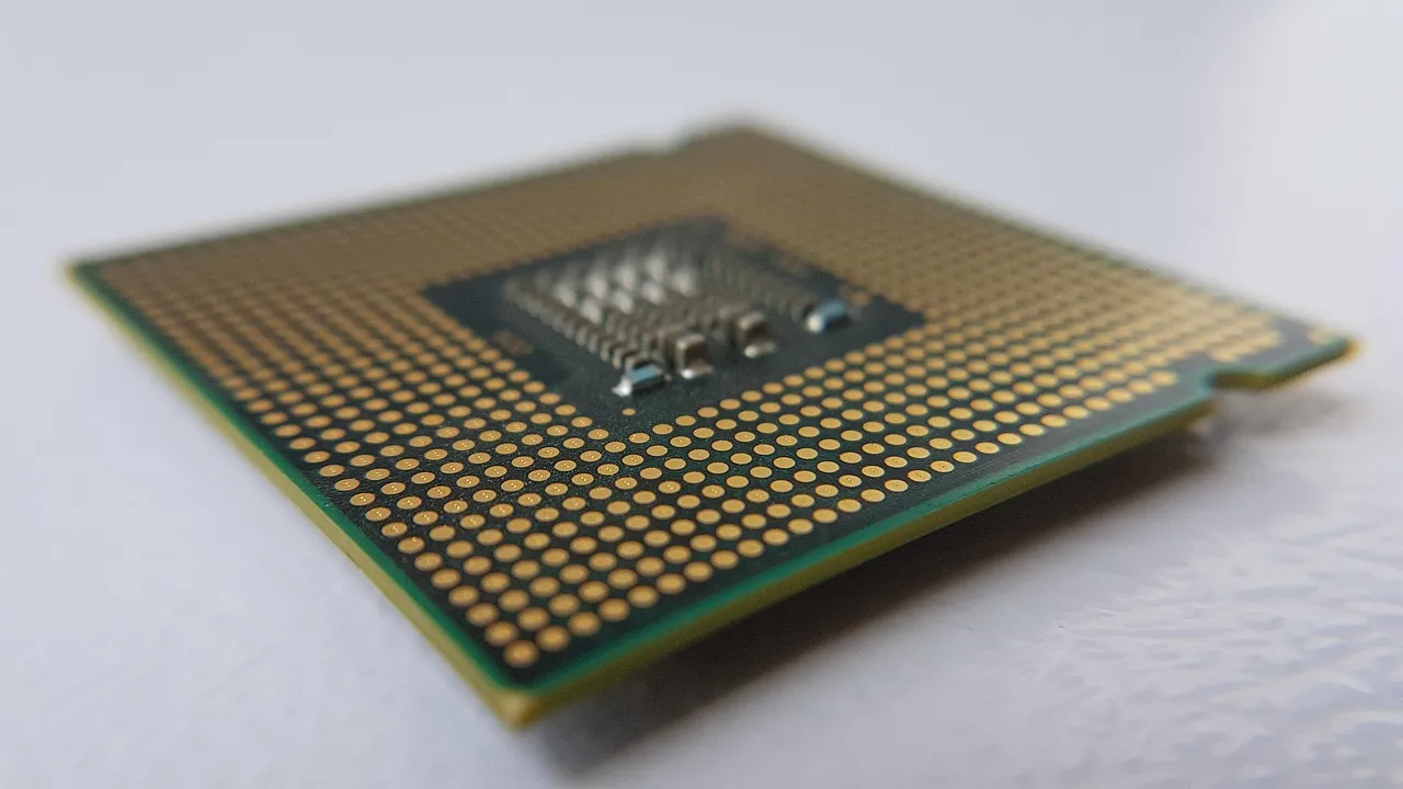 Close-up of a packaged computer chip showing its gold contact pads