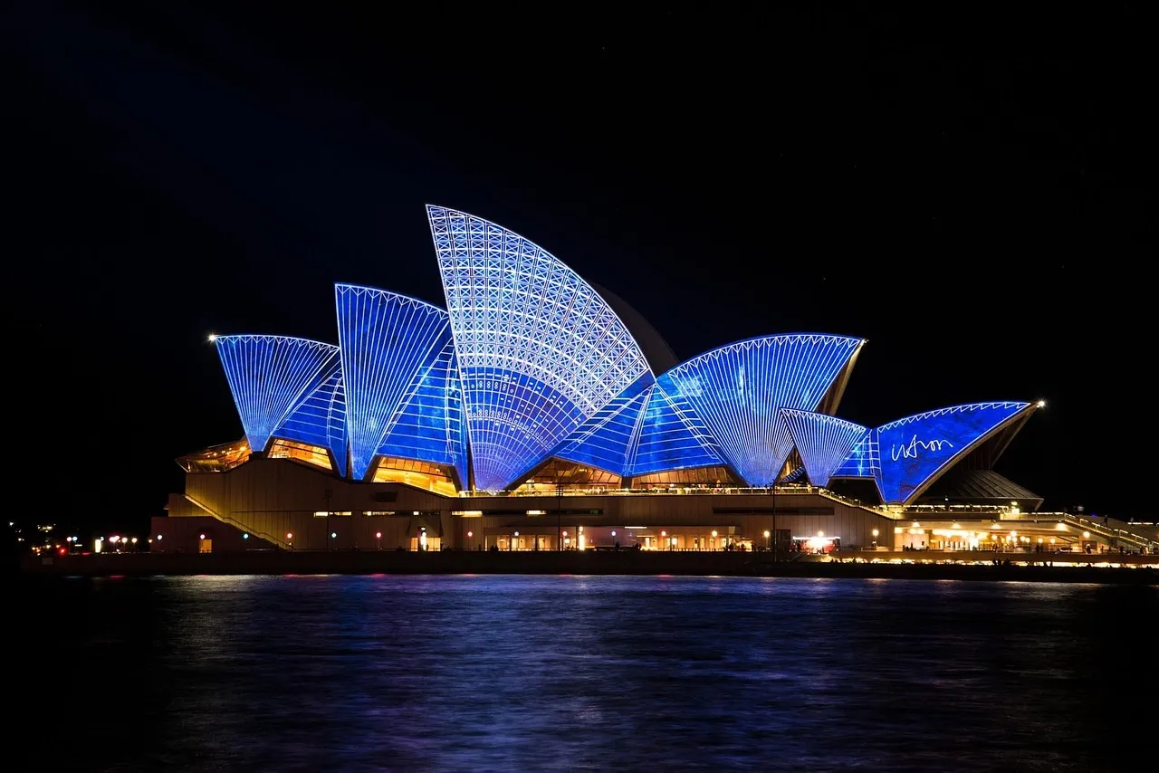 The Sydney Opera House lit against the harbour after dark