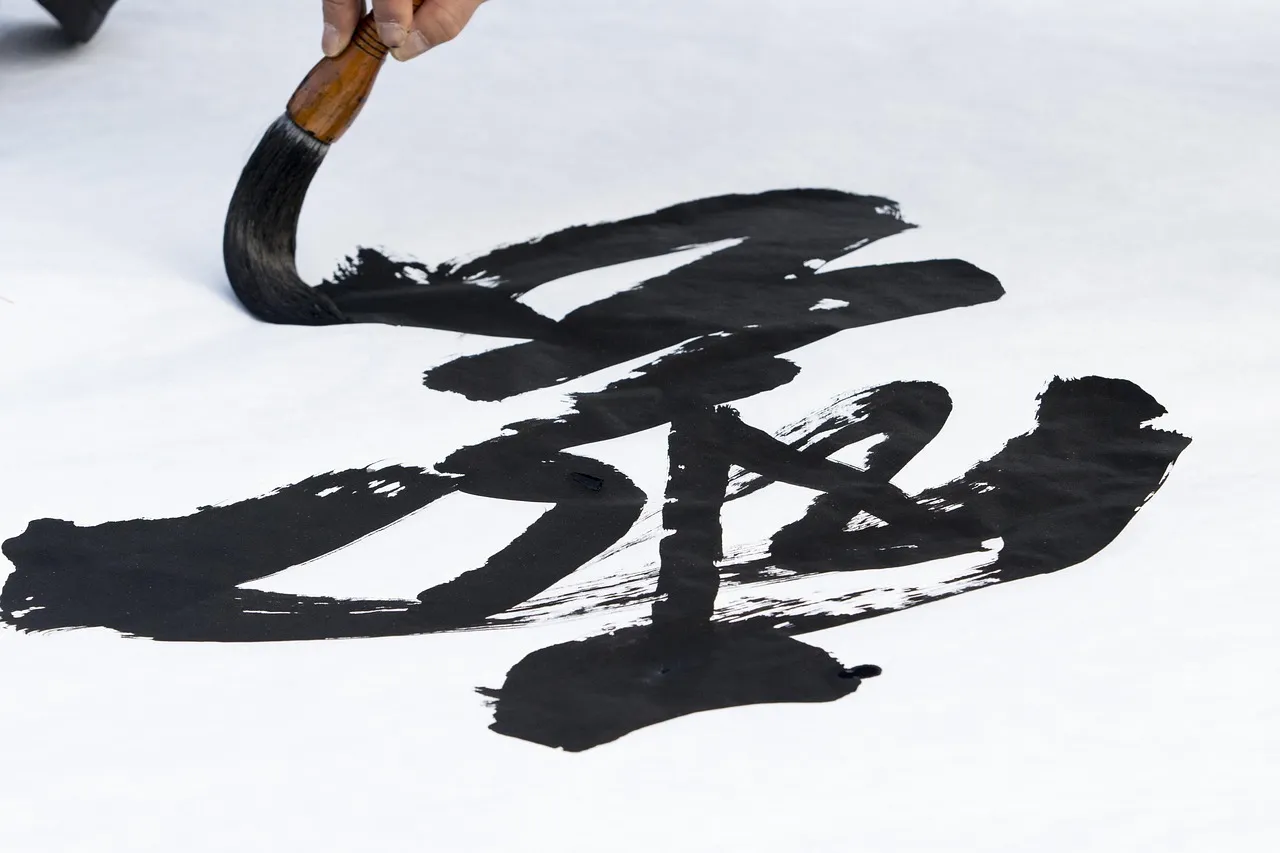 A calligraphy brush on an ink stone in front of practice characters