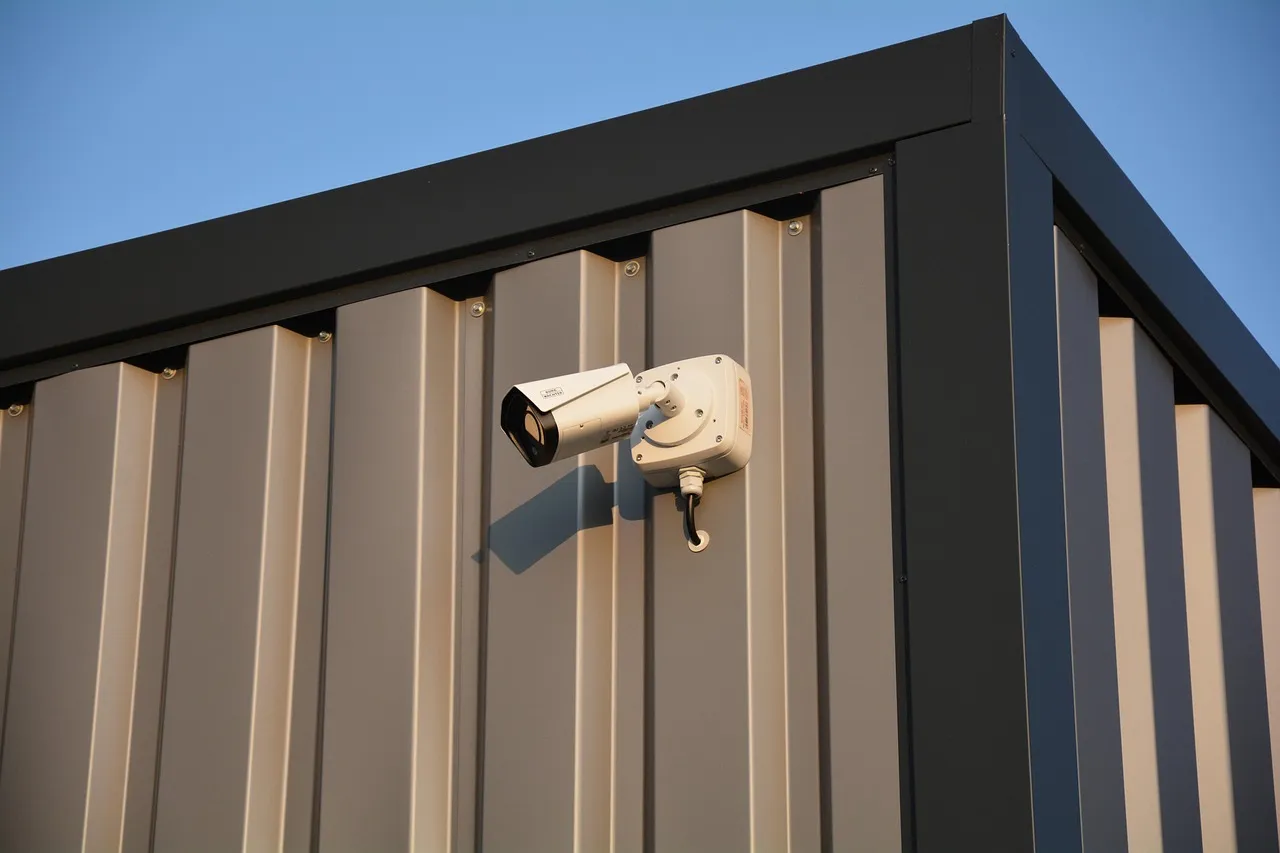 A security camera mounted on the outside wall of a building, where TAKE stores a recovery key by default