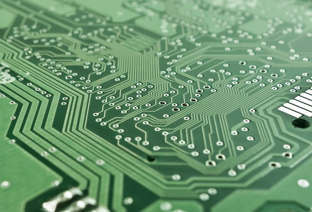 Close-up of a green printed circuit board, illustrating a report on SMIC mature-node foundry capacity and rising wafer prices.