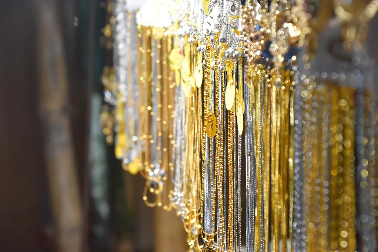Rows of gold and silver chains hanging on display in a jewellery shop