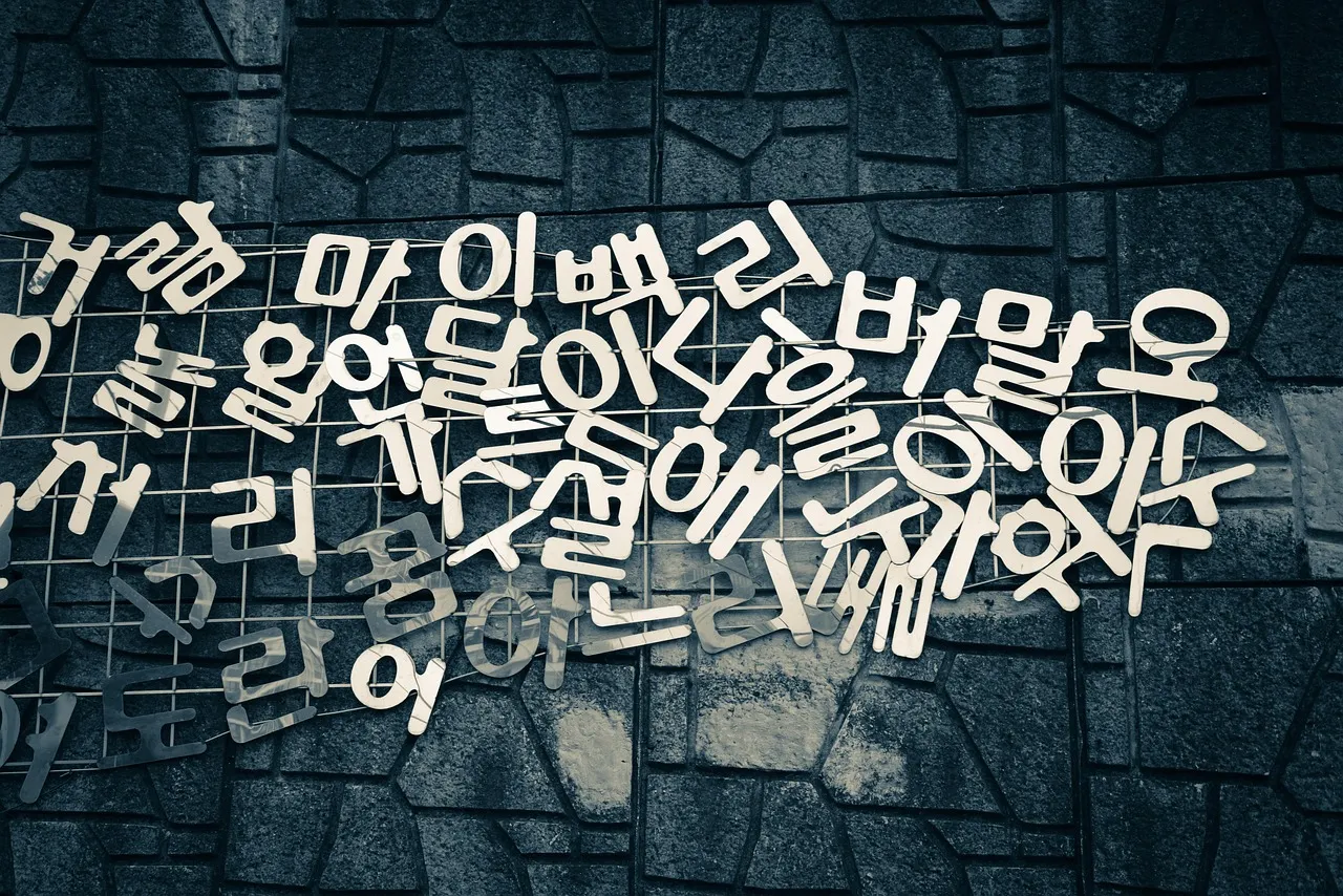 White Hangul letters scattered and overlapping across a dark textured surface.