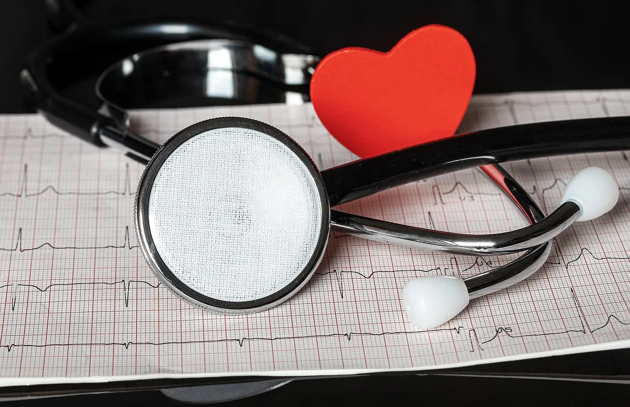 A stethoscope and a red heart shape resting on an electrocardiogram printout
