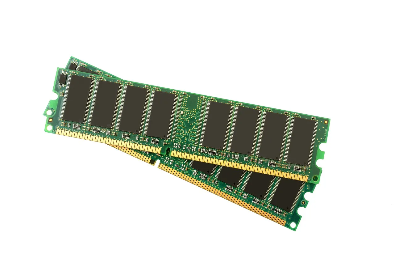 Two green DRAM memory modules lying on a white surface, their chips and contacts visible.