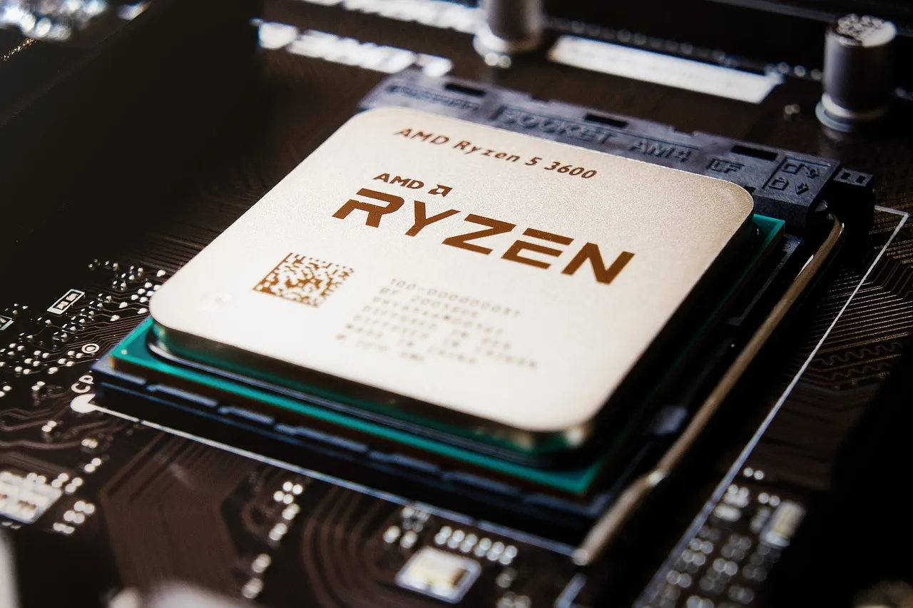 An AMD Ryzen processor resting on a motherboard beside its socket.
