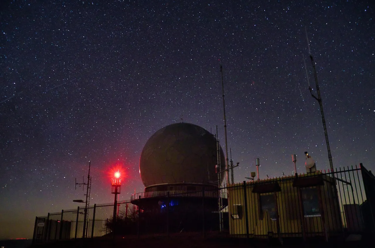 An observatory dome at night under a starry sky