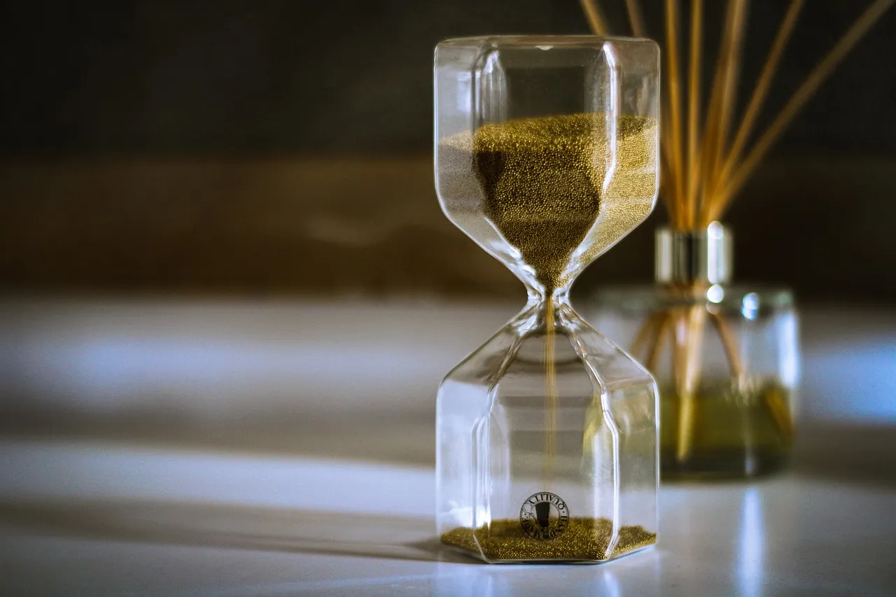 Hourglass on a desk with the sand part-run, illustrating the waiting periods these two registry rules impose.