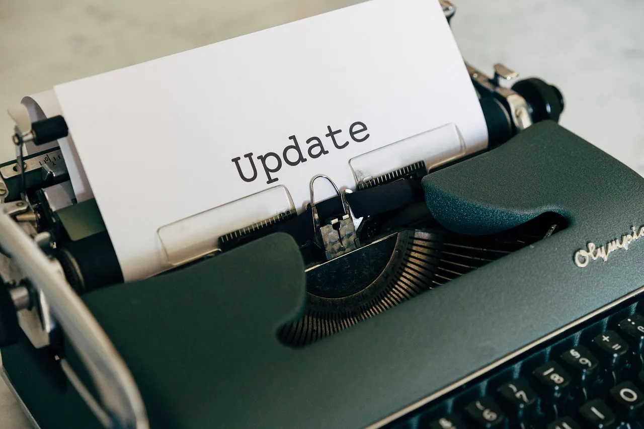 A sheet of paper in an old Olympia typewriter carrying the single typed word Update