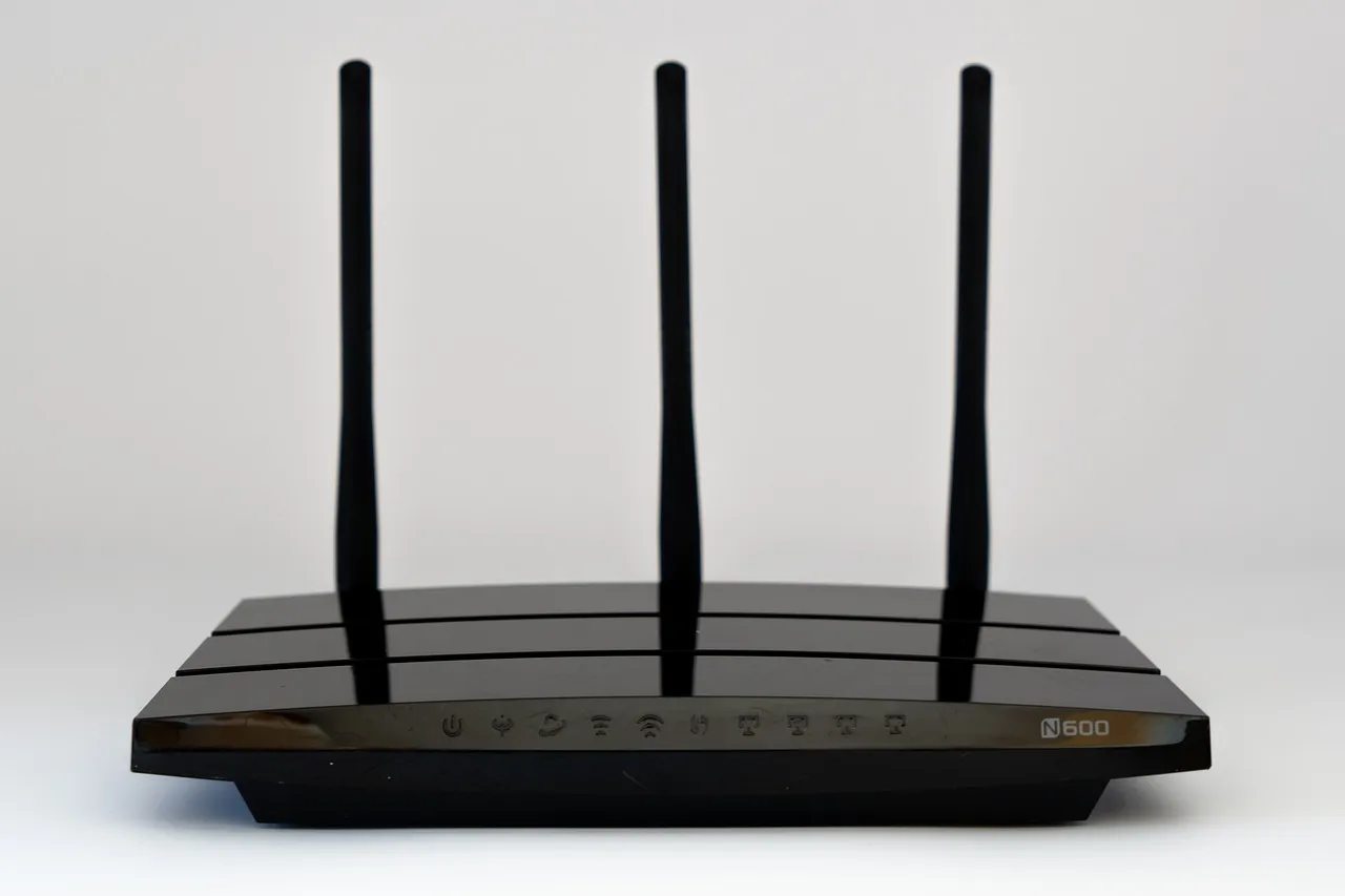 A wireless router with three antennas, the hardware category the Huawei and HP Wi-Fi patent licence covers