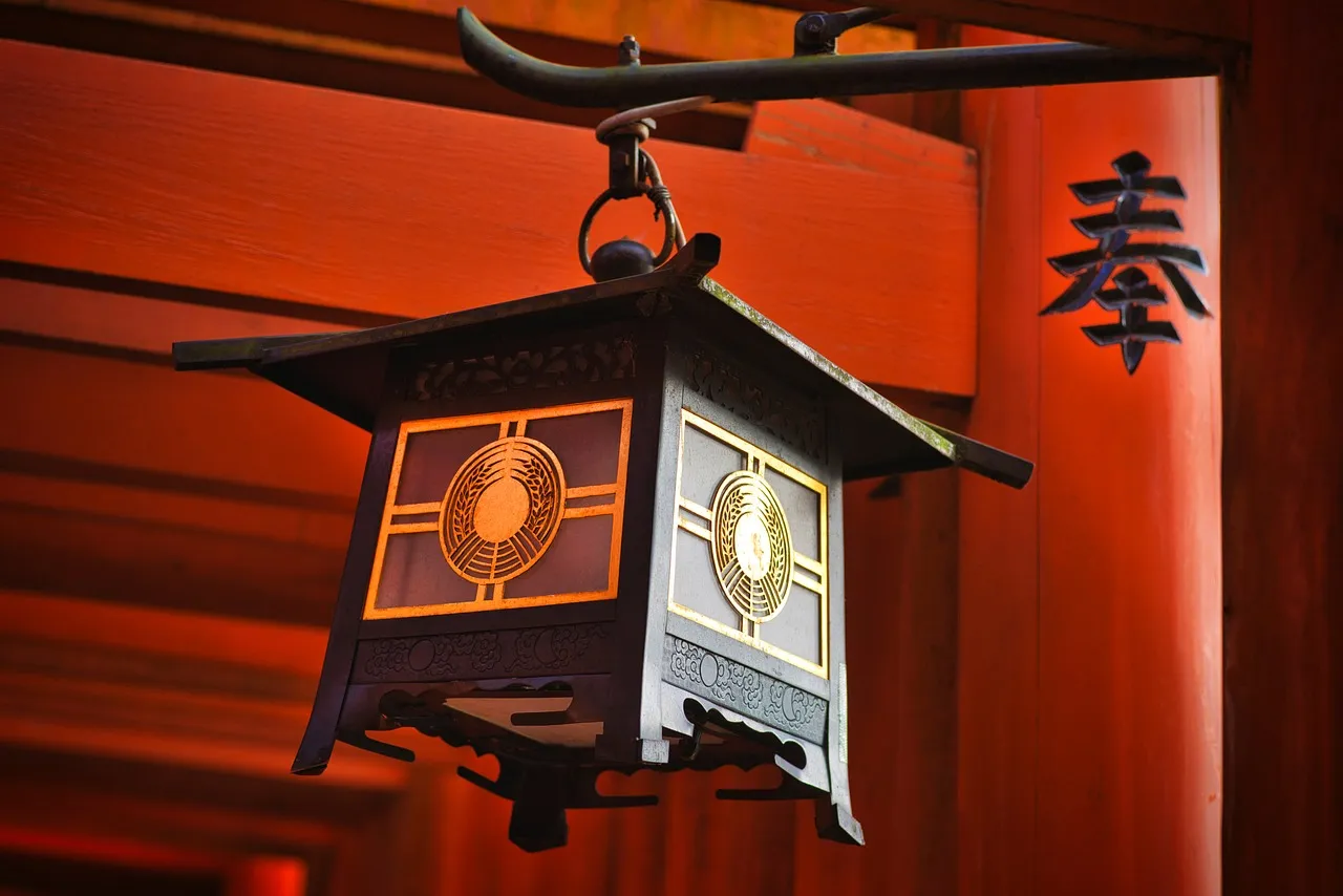 A lantern hanging beneath the red eaves of a Japanese shrine