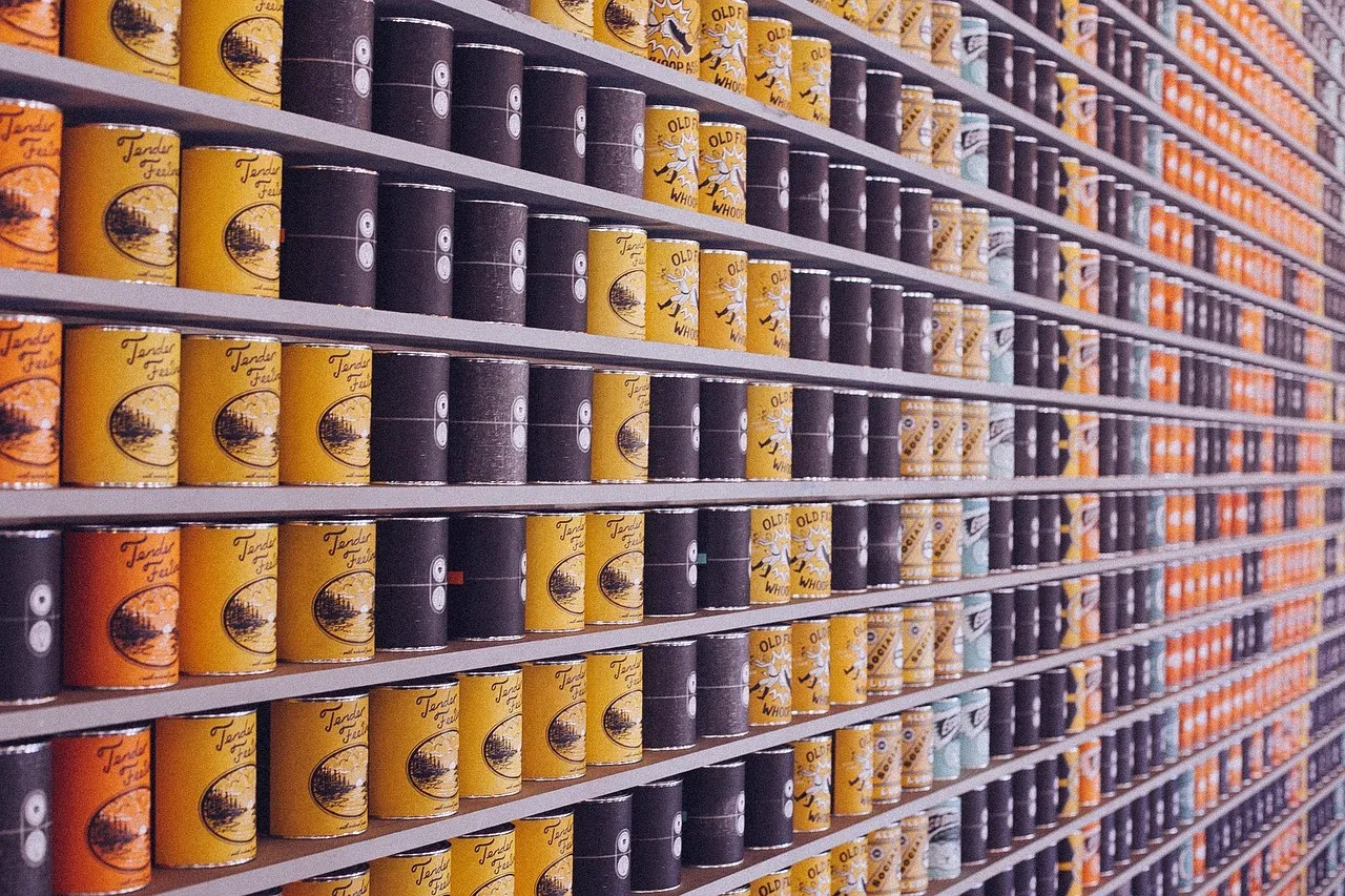 Rows of canned food stacked along a supermarket shelf.