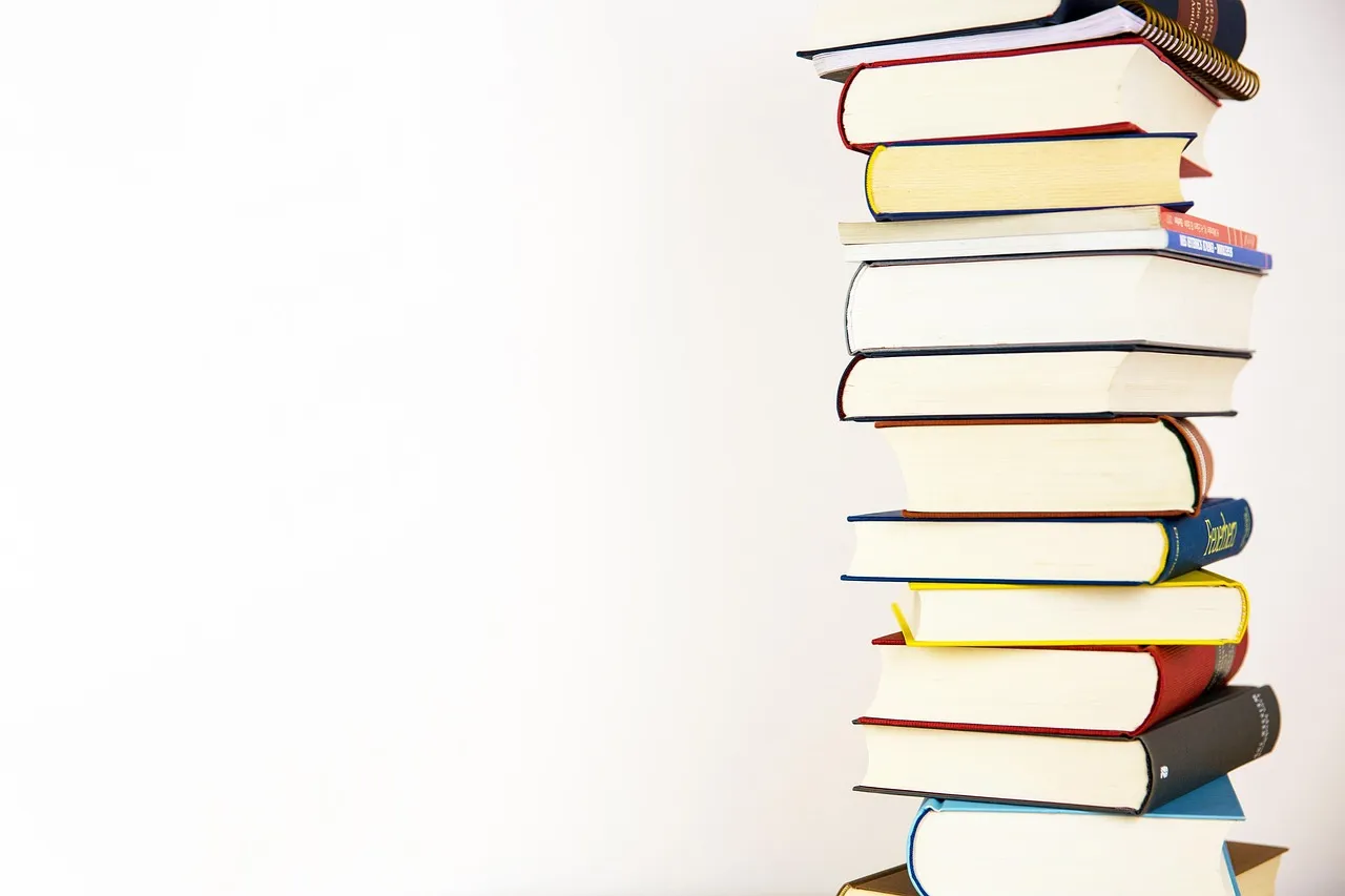 A tall stack of hardback books against a plain white background