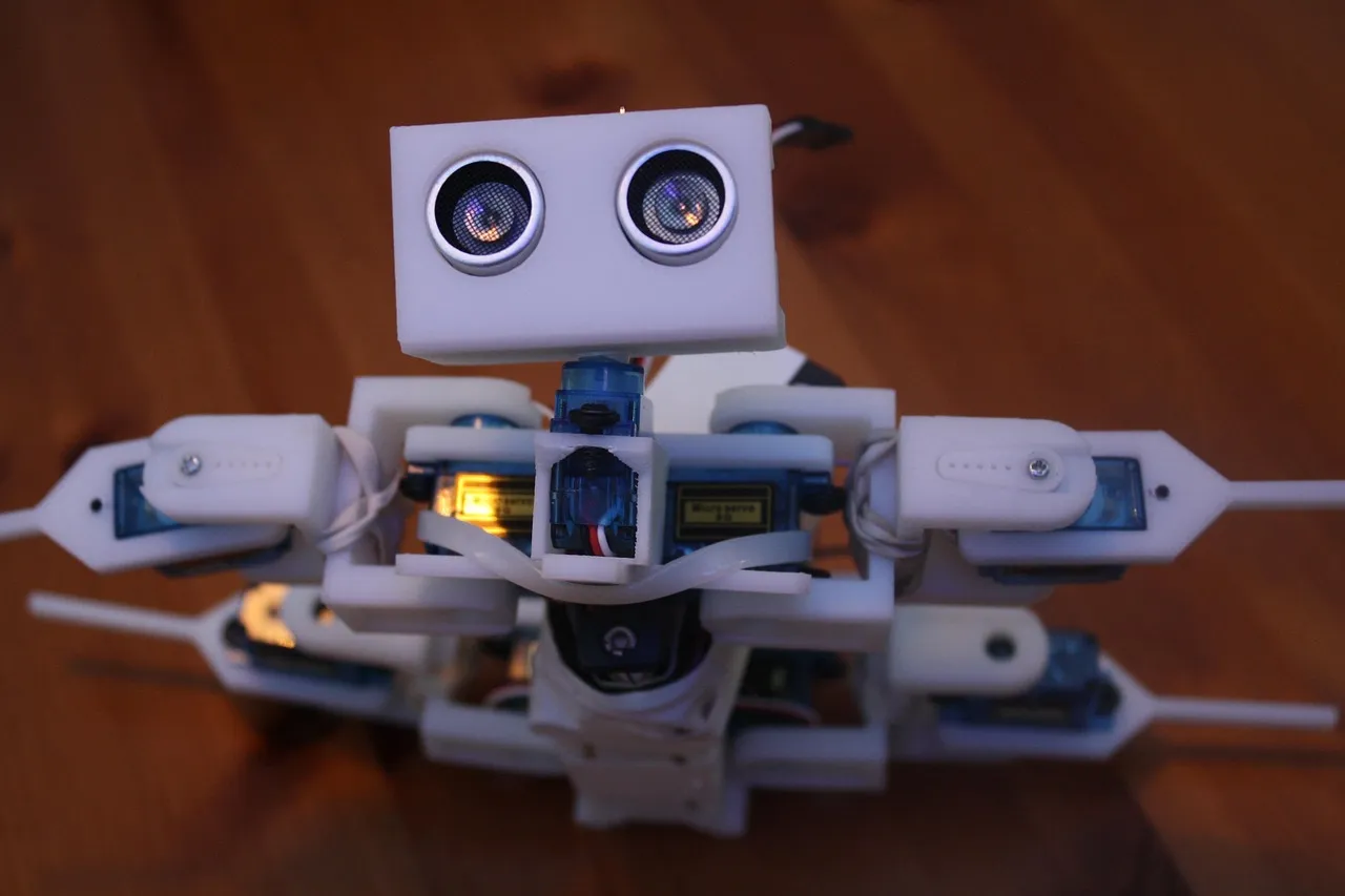 A small hobbyist robot with exposed servos and range sensors, the class of machine Microduck belongs to