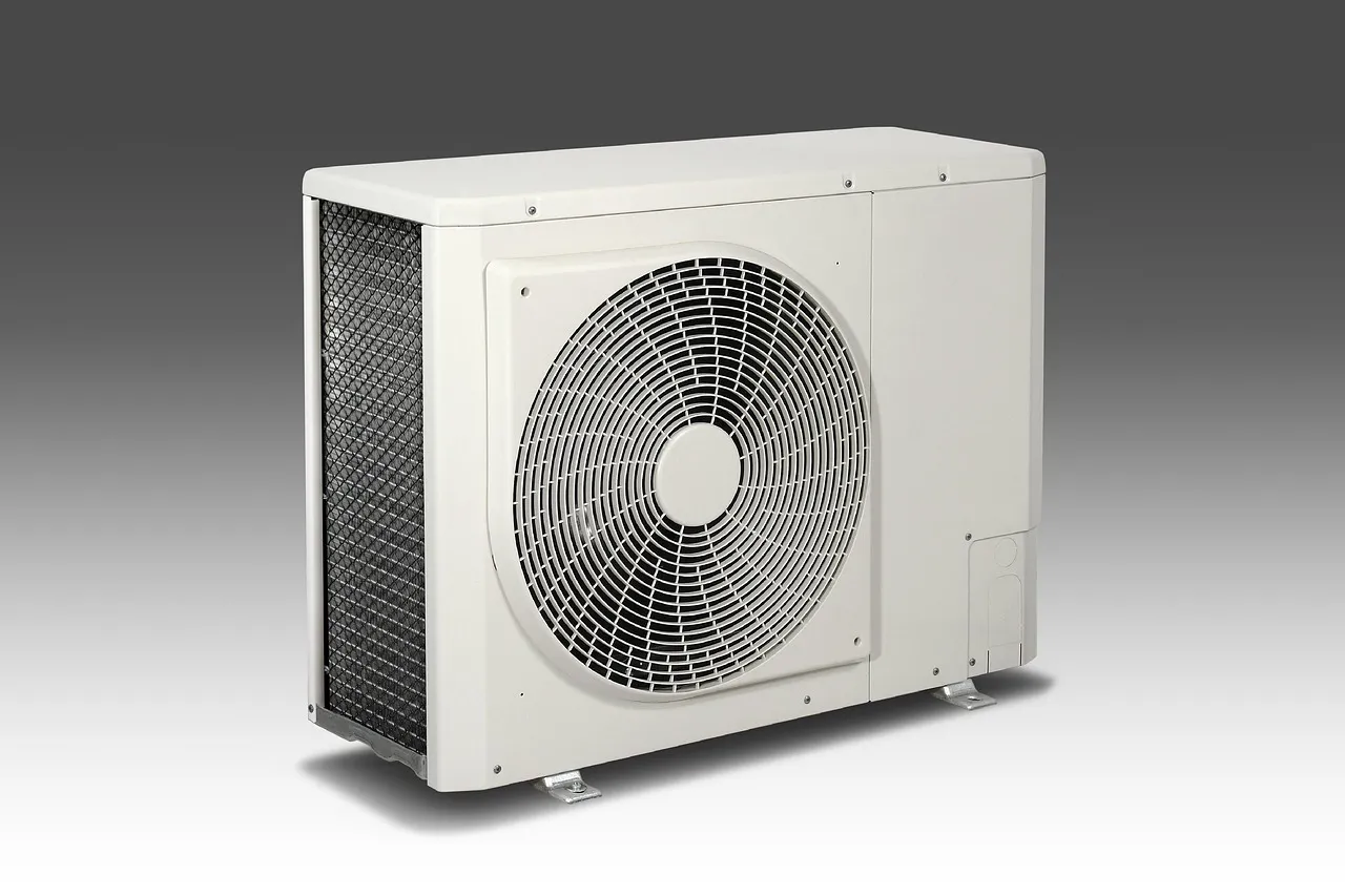 A white outdoor air-conditioning condenser unit with a large circular fan grille, against a plain background