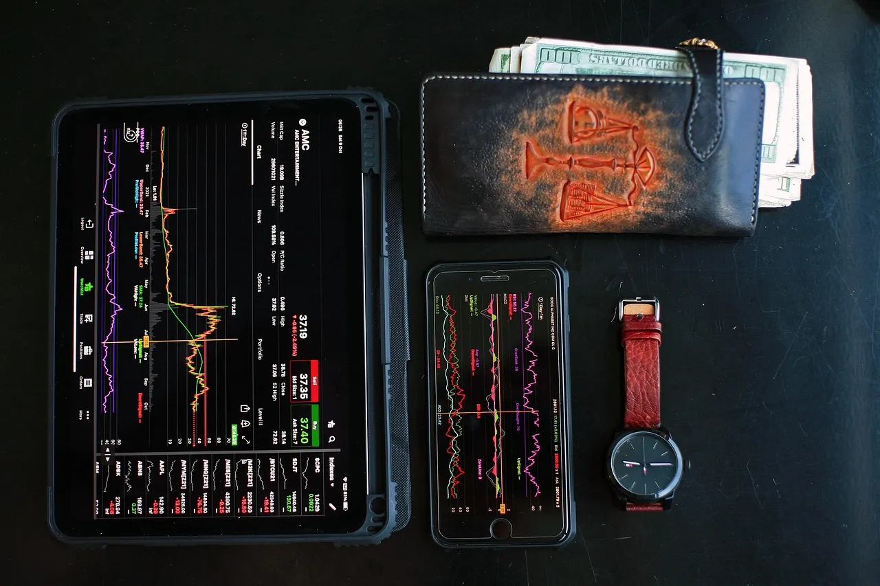 Printed financial charts and a notebook arranged on a dark desk
