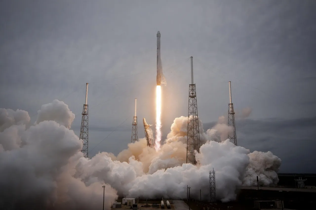 A rocket lifting off from a coastal launch pad, engines lit through the exhaust plume.