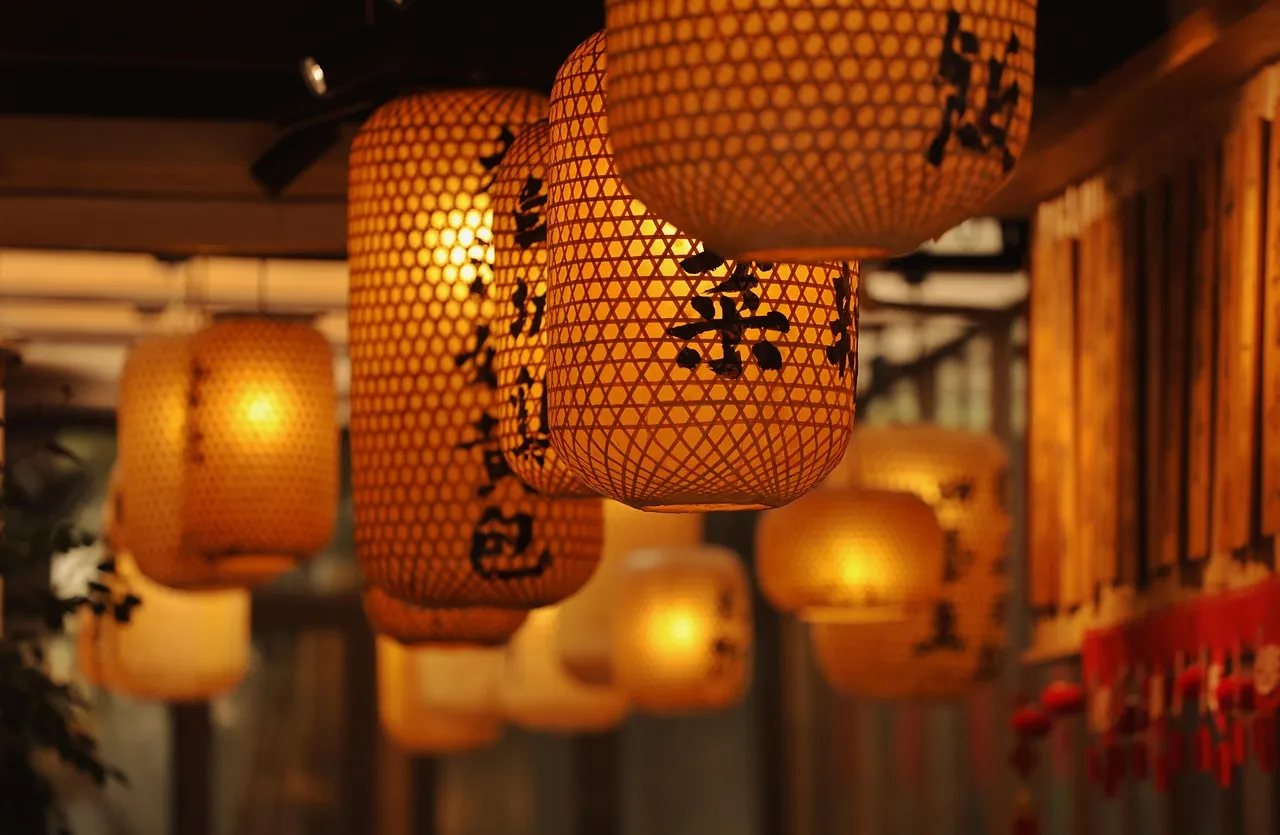 Lit paper lanterns with Chinese characters hanging in a row