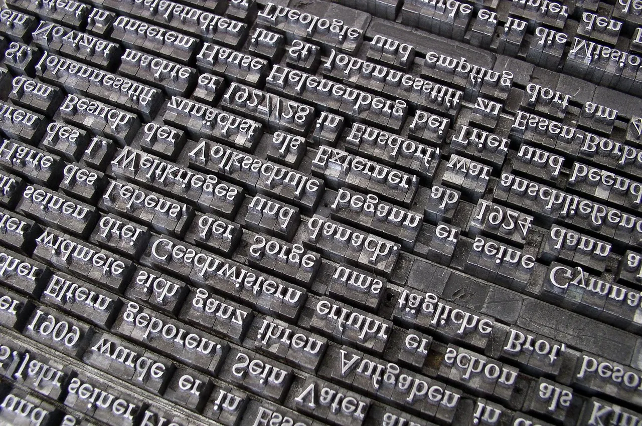 Rows of set metal letterpress type, the letters mirror-reversed as they are on real printing sorts.