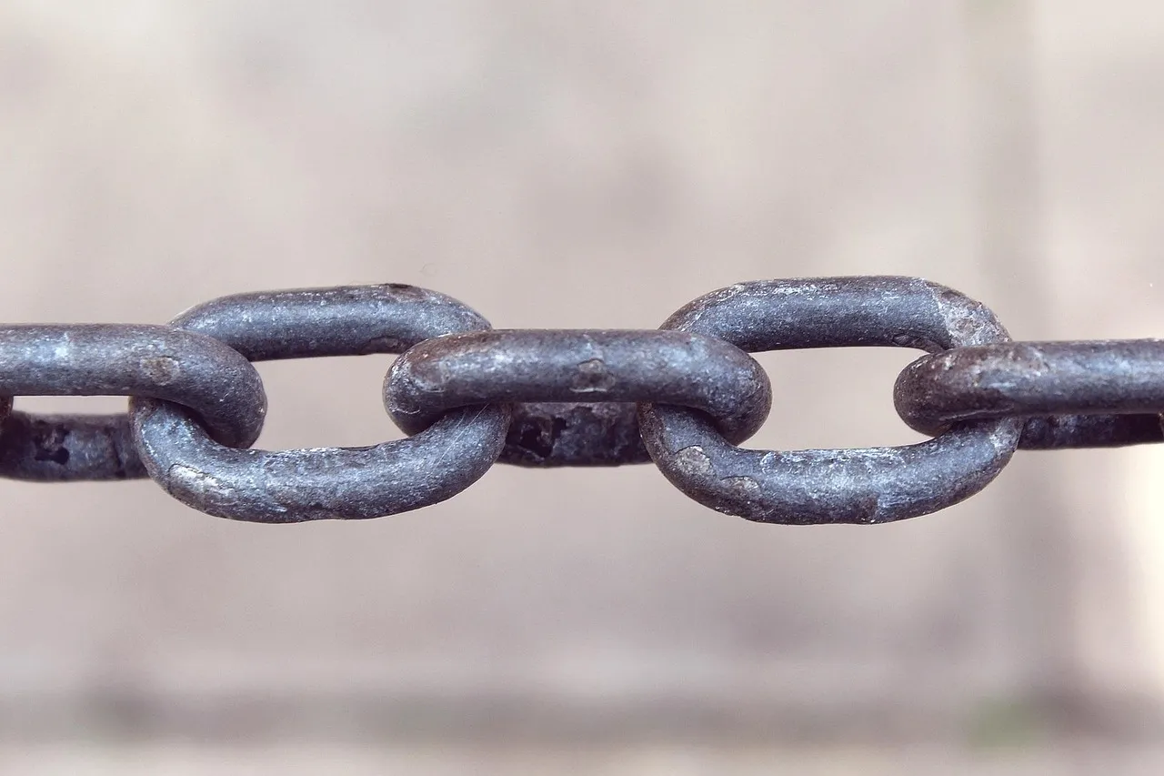 Close-up of a heavy chain in which one link is visibly more worn than its neighbours — illustrating a fix that depends on an older underlying library.