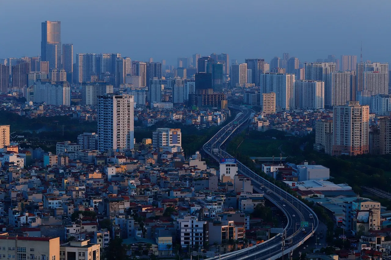 A dense city skyline of high-rise towers crossed by an elevated road