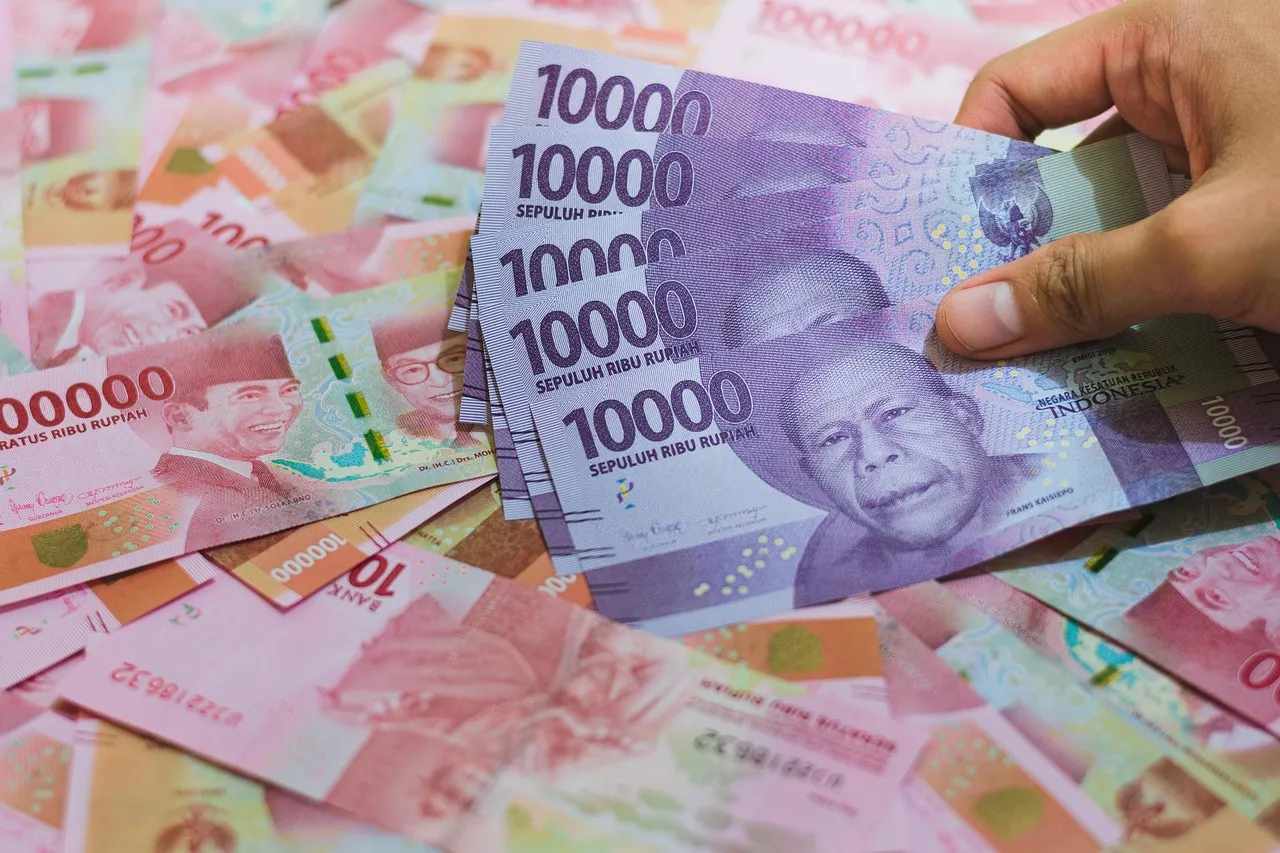 Indonesian rupiah banknotes of 10,000 and 100,000 held in a hand