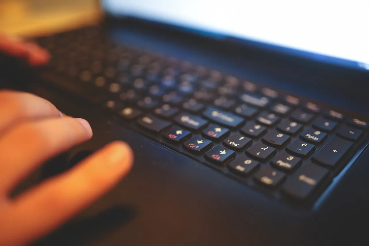 A hand resting on a laptop keyboard, illustrating the per-command approval this study measured.