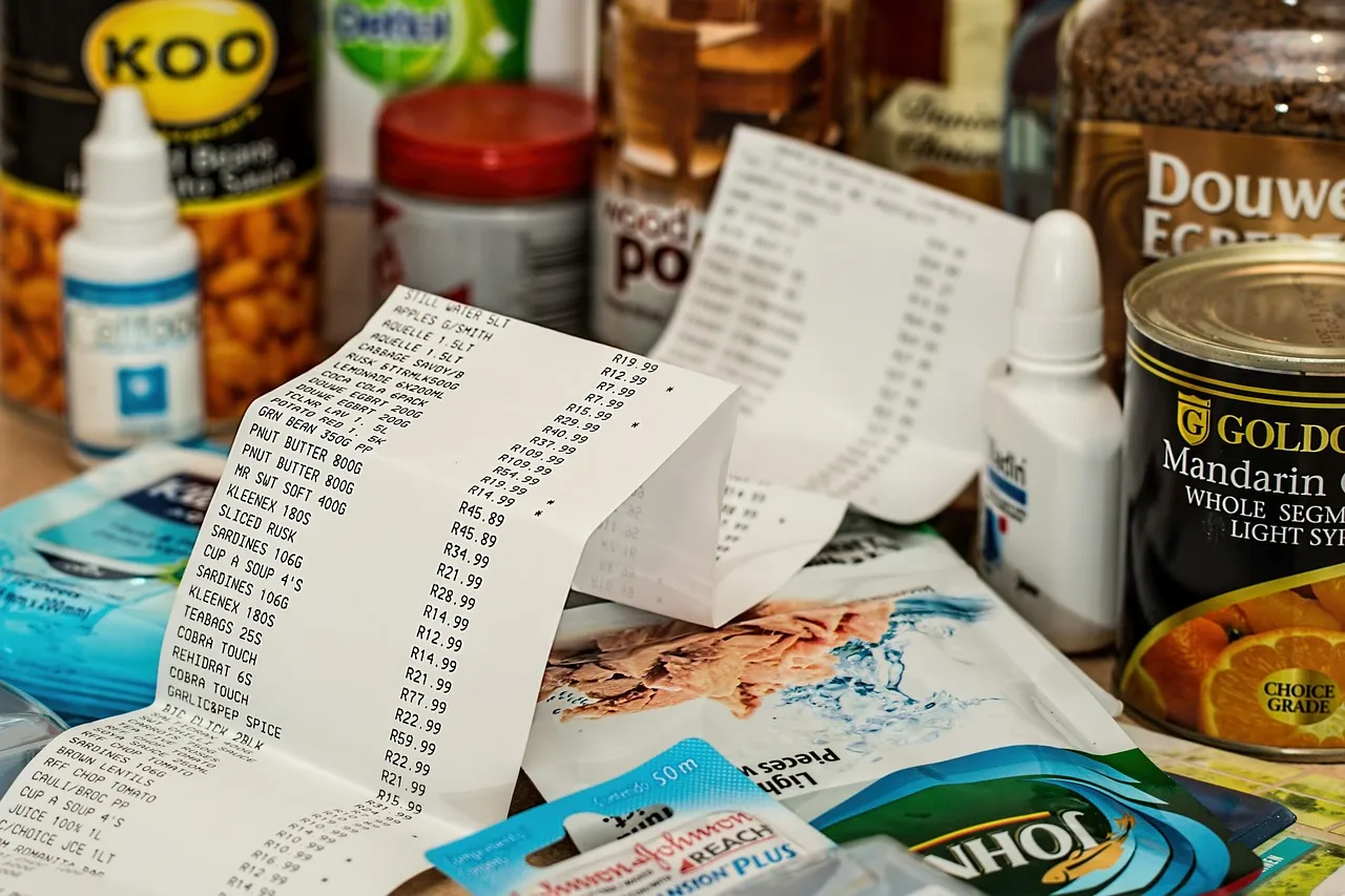 A long supermarket receipt lying across packets and tins of groceries.